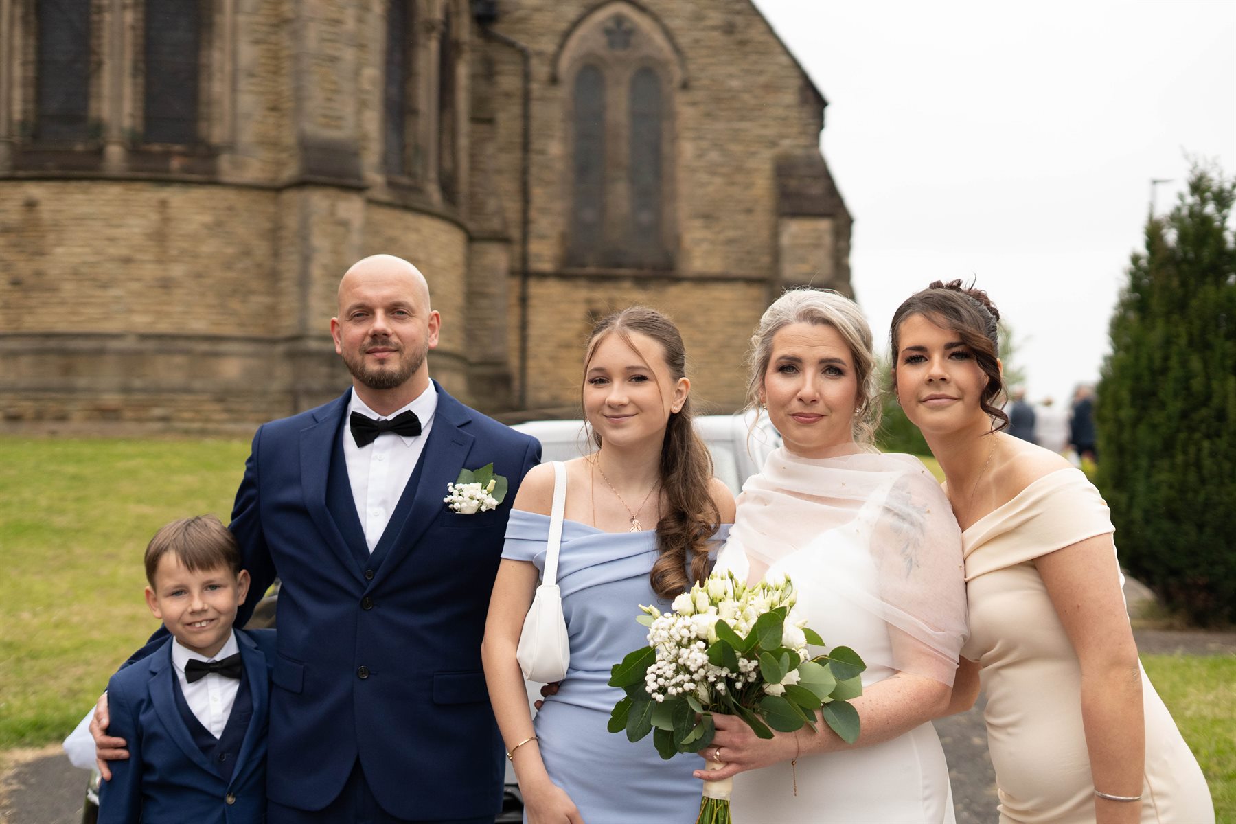 Wedding family portrait outside church by Peter Szafel